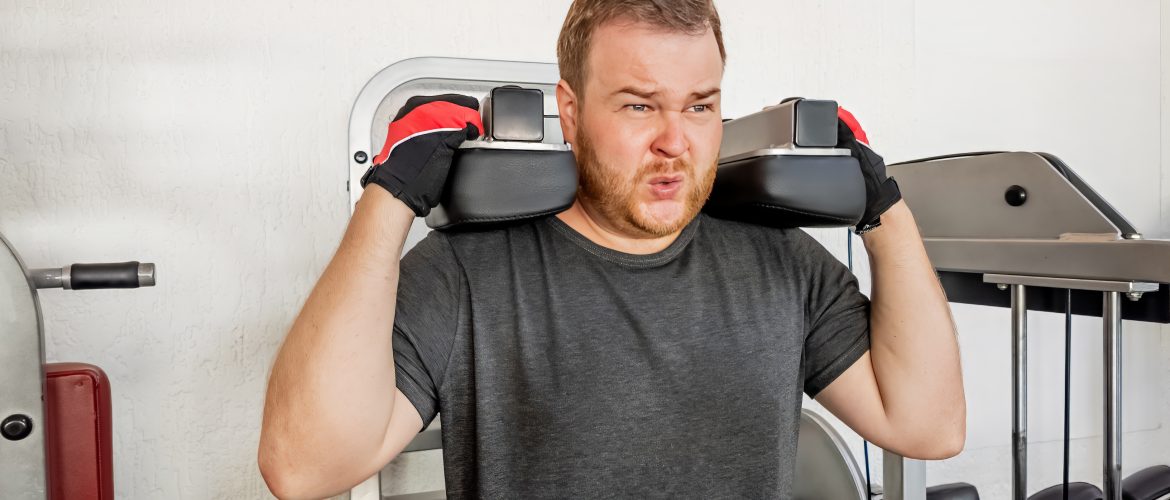Beginner gym mistakes man struggling with weightlifting form in a gym scaled